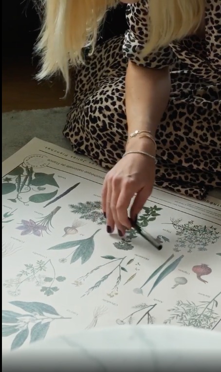 Isabelle Diacono, fondatrice des Jolies Planches, penchée sur une de ses éditions : la planche Plantes Aromatiques.